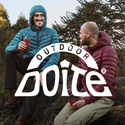 Two men in puffer jackets enjoying drinks outdoors, showcasing outdoor adventure gear.