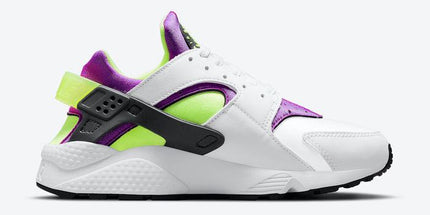 White sneaker with purple and neon green accents, black strap, and textured sole